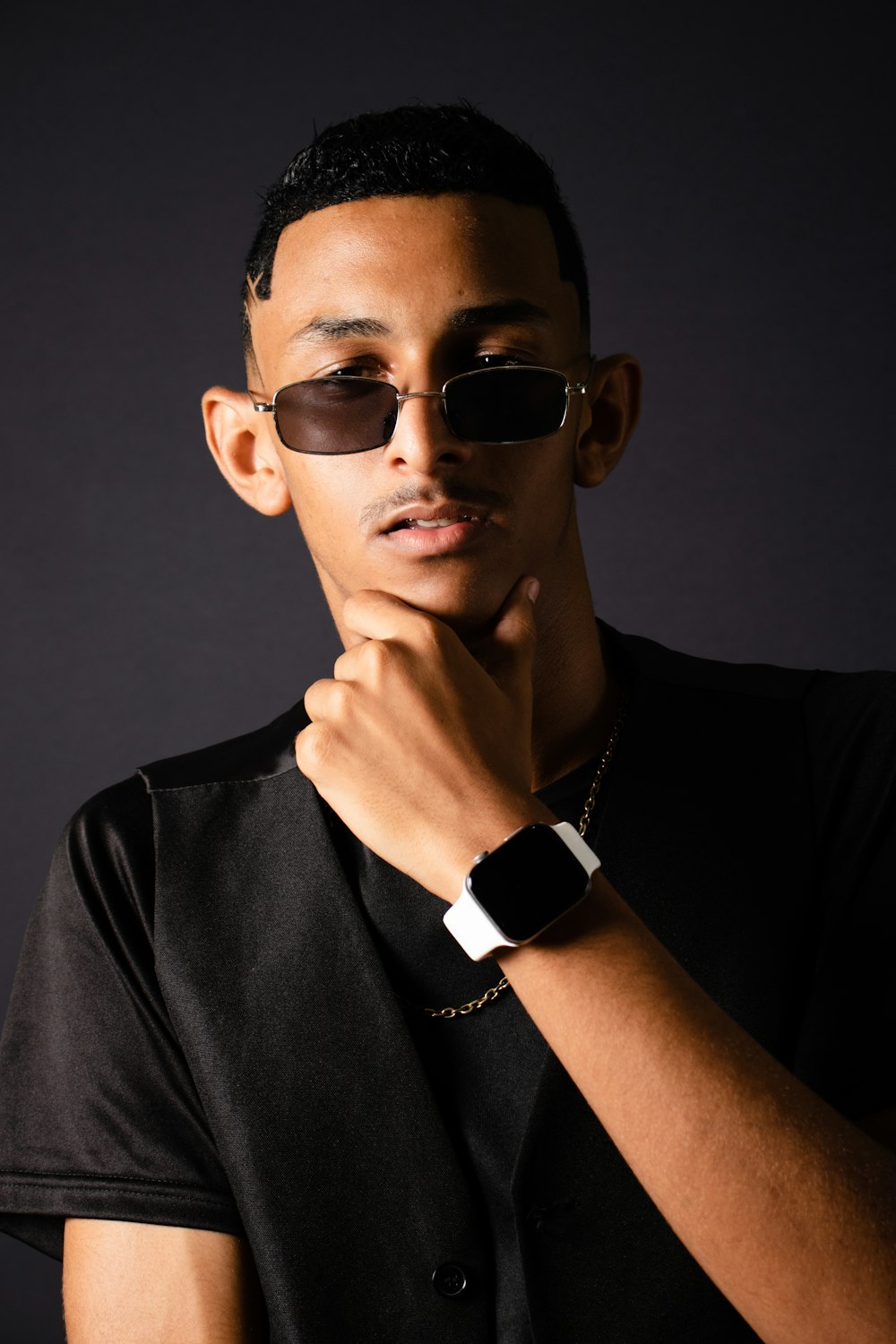 a young man wearing sunglasses and a black shirt