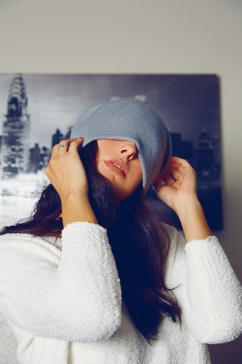 a woman in a white sweater and a blue hat