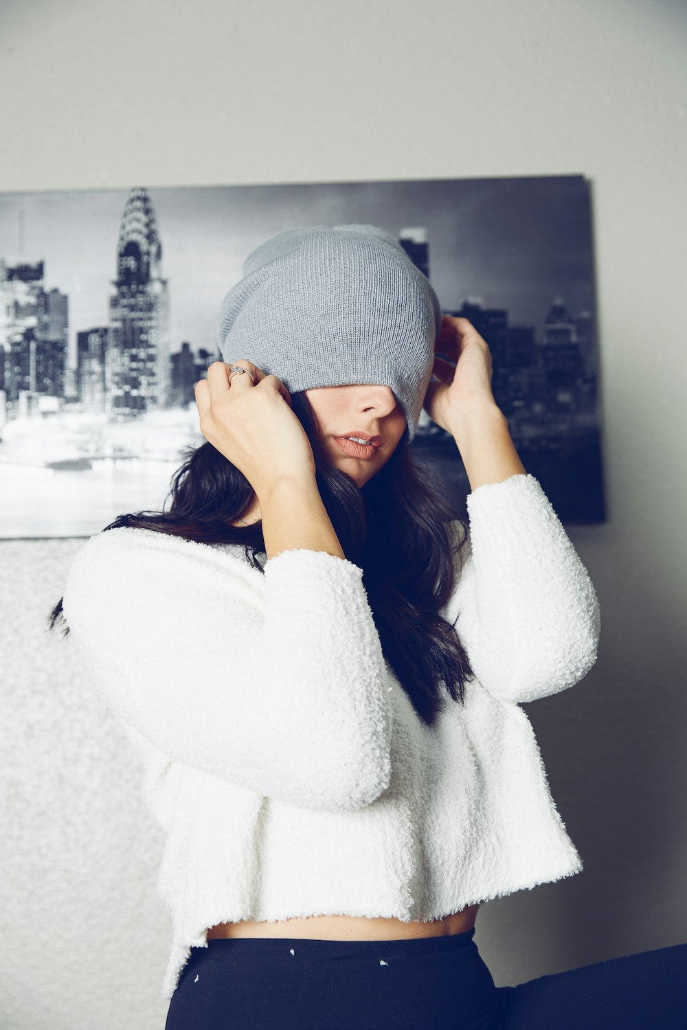 a woman wearing a white sweater and a gray beanie