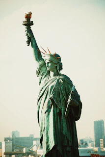 Statue of the blindfolded goddess of justice standing tall with the Andes mountains in the background at sunset.