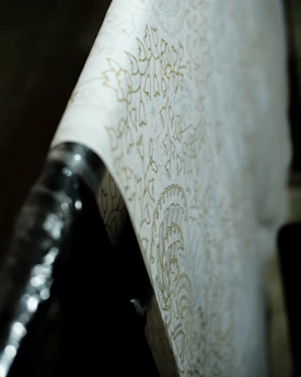 Close-up of a craftsman smoothing wallpaper on a softly lit living room wall.