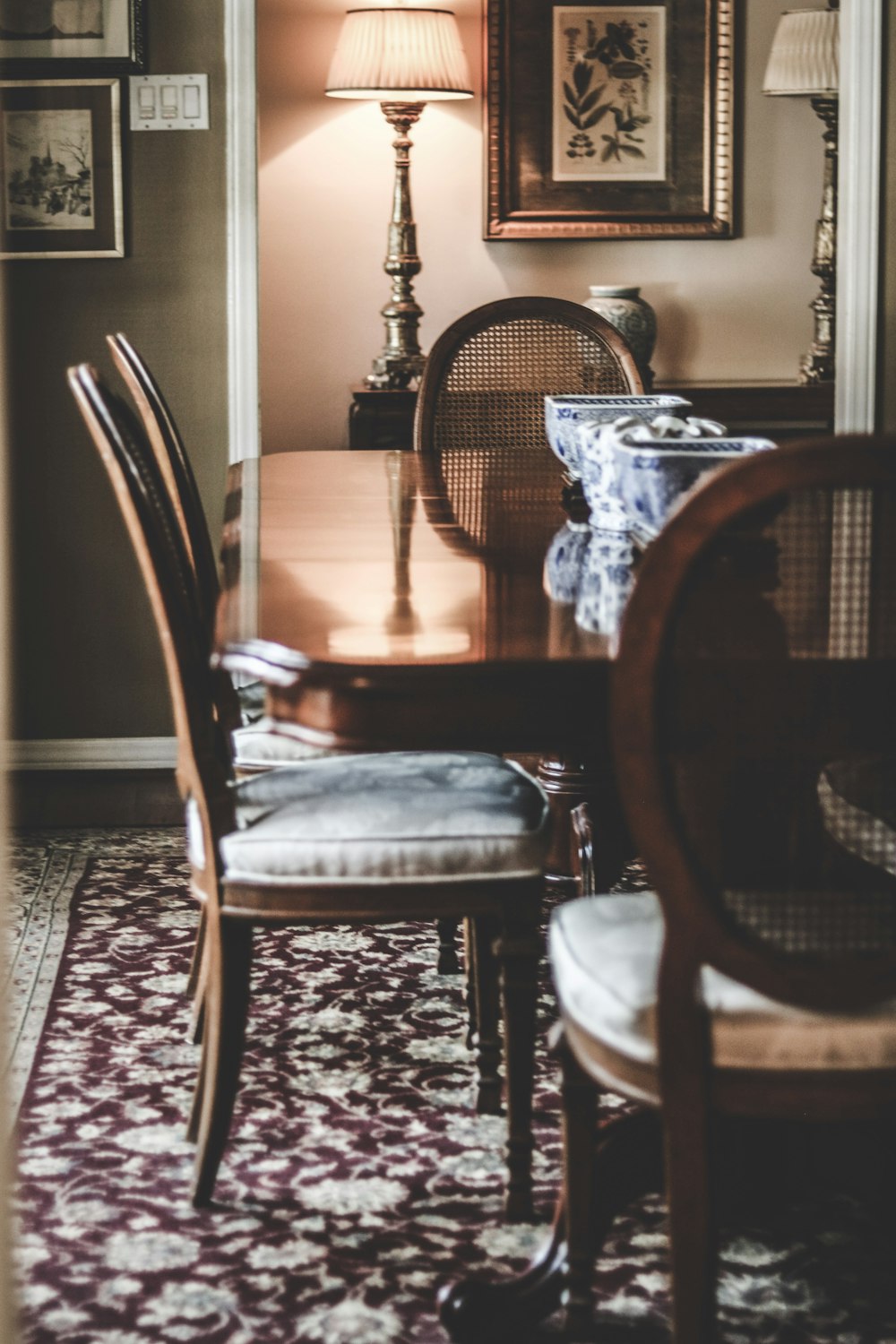 a dining room table with chairs and a lamp