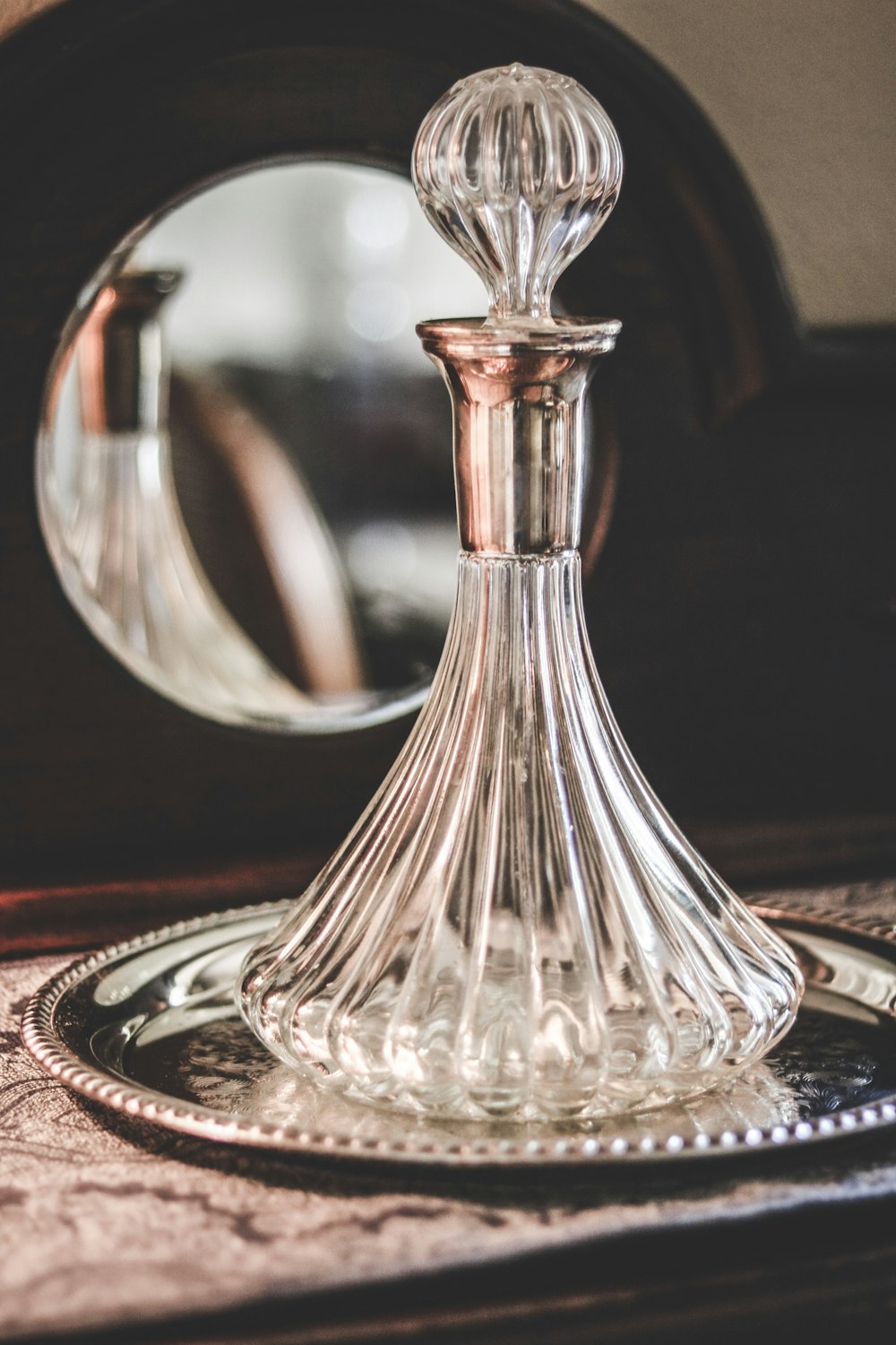 a glass bottle sitting on top of a silver plate