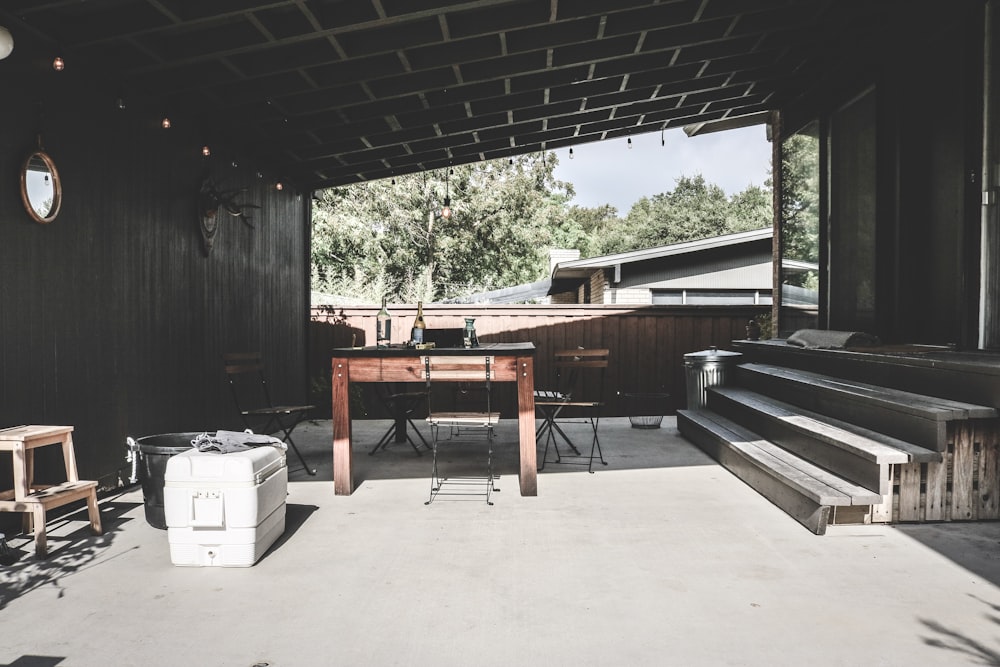 a covered patio with a table and benches