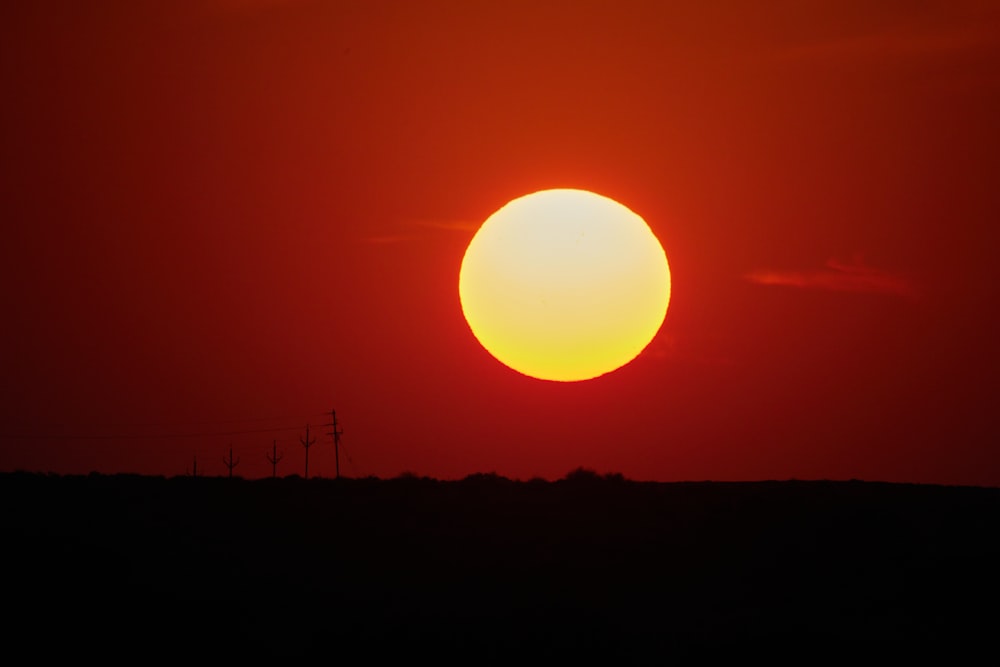 the sun is setting in the sky over a field