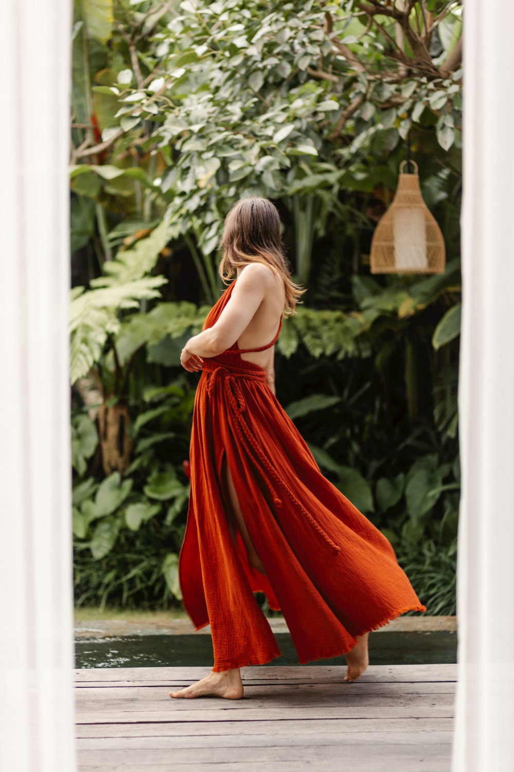 a woman in a red dress is standing outside