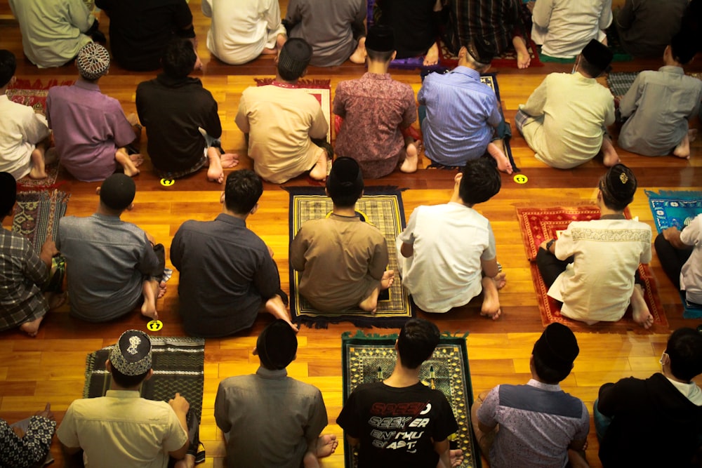 a group of people sitting on top of a wooden floor