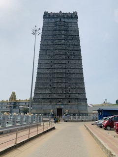 Car parked at the foot of the majestic Konark Sun Temple with travelers preparing to explore