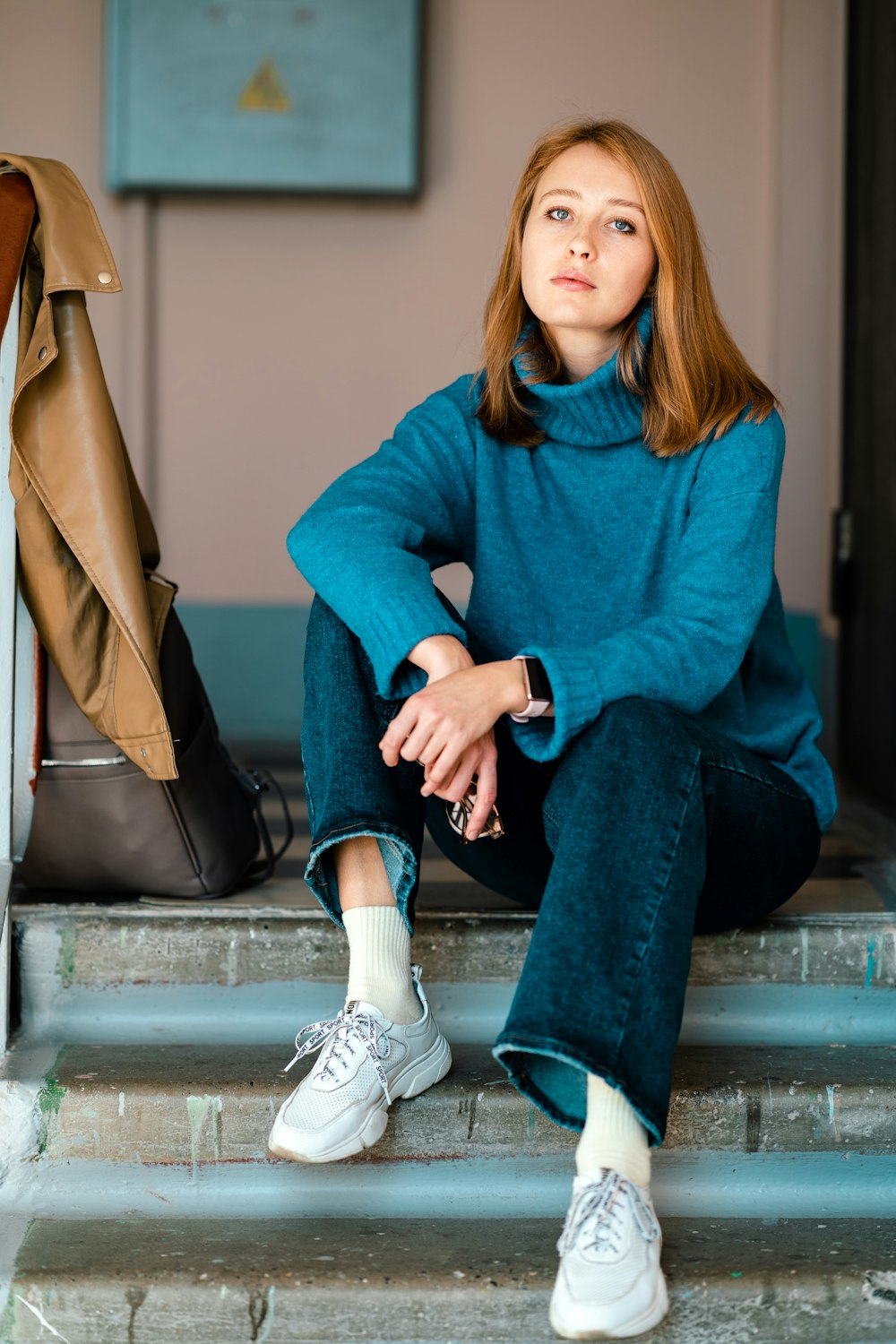 a woman sitting on the steps of a building