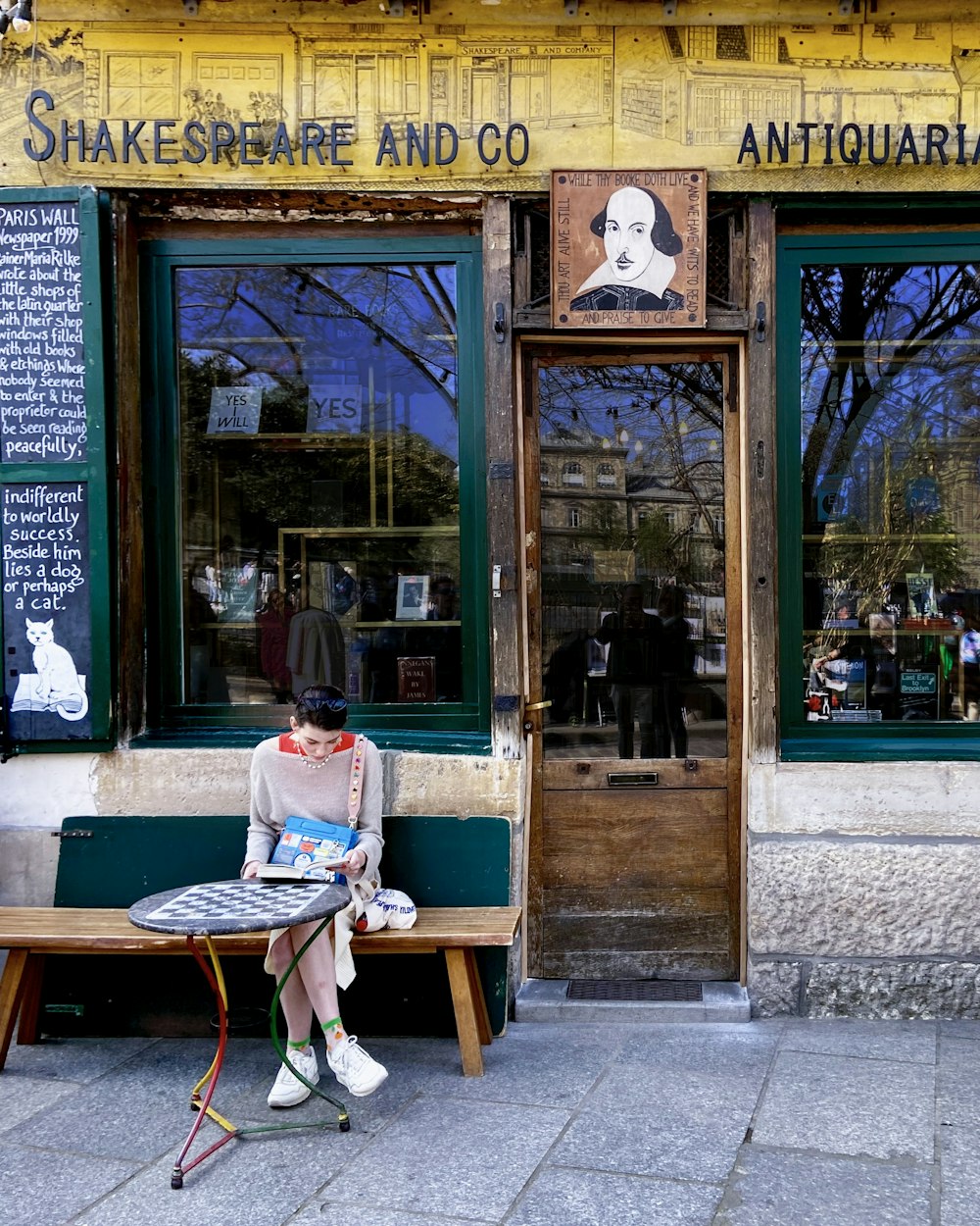 a person sitting on a bench in front of a store