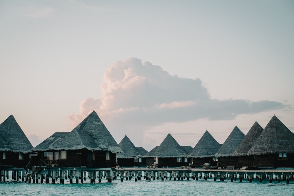 a row of huts sitting on top of a body of water