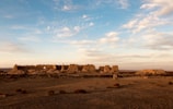 Sunset over a misty archaeological site with scattered ruins