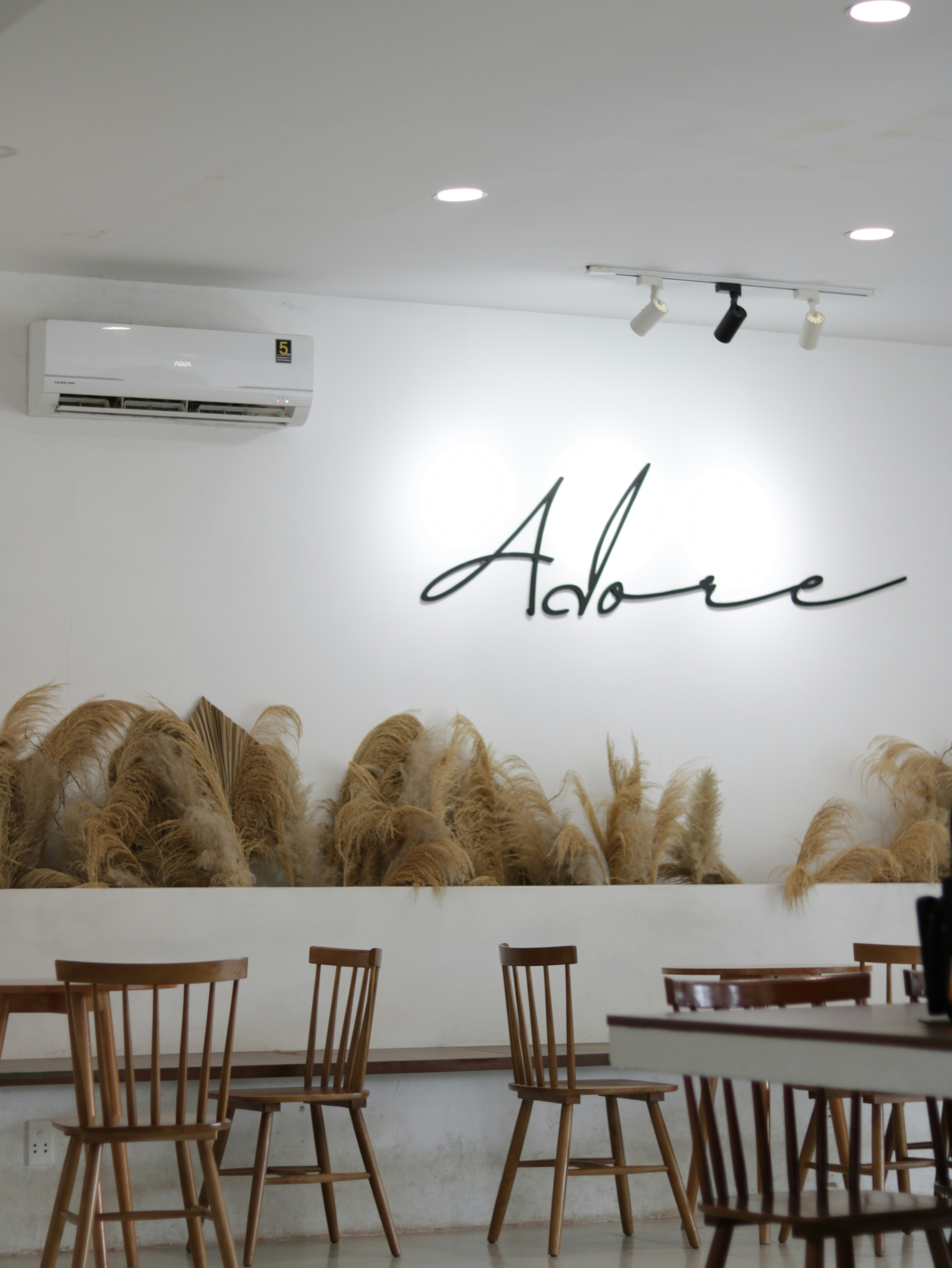 A restaurant with chairs and a wall with a name written on it