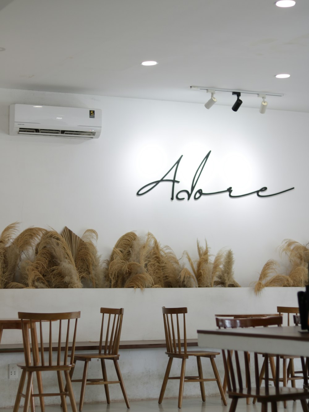 a restaurant with chairs and a wall with a name written on it