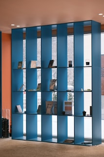 a room with a blue bookcase and a window