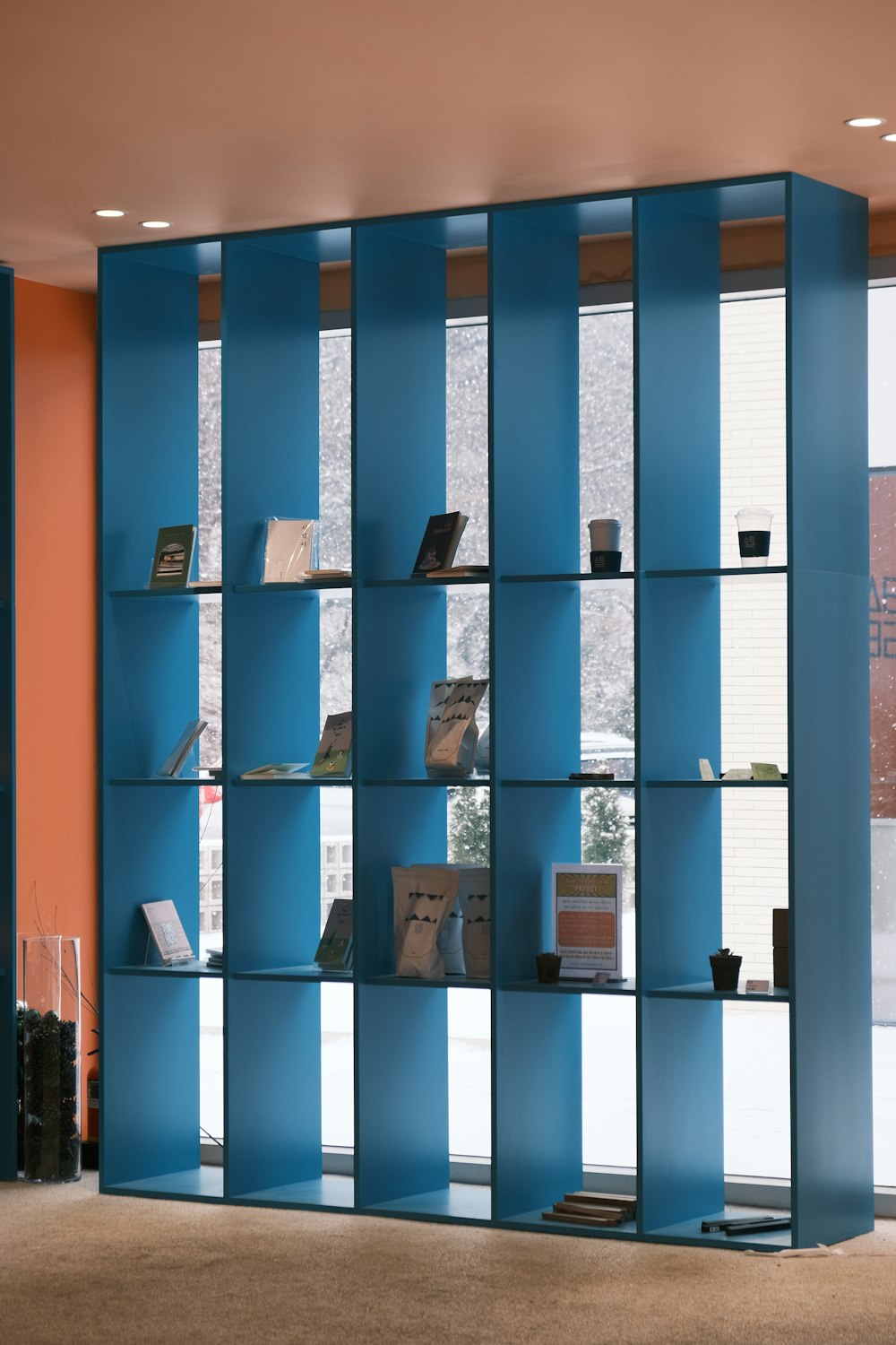 a room with a blue bookcase and a window