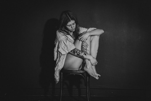 a black and white photo of a woman sitting on a chair