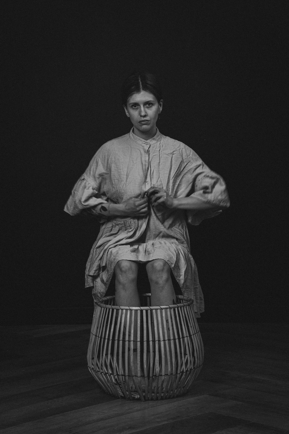 a black and white photo of a woman sitting in a basket