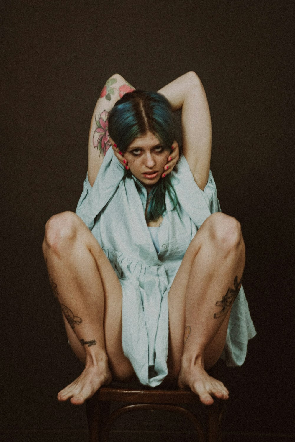 a woman sitting on top of a wooden chair