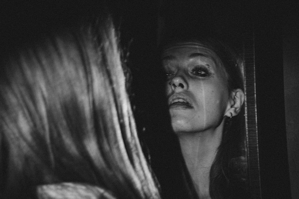 a woman looking at herself in a mirror