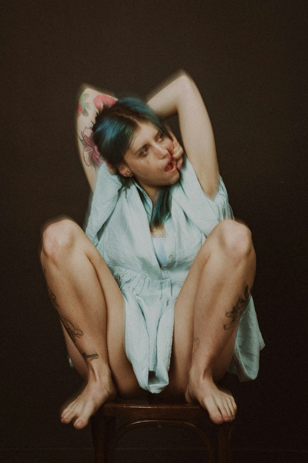 a woman sitting on top of a wooden chair