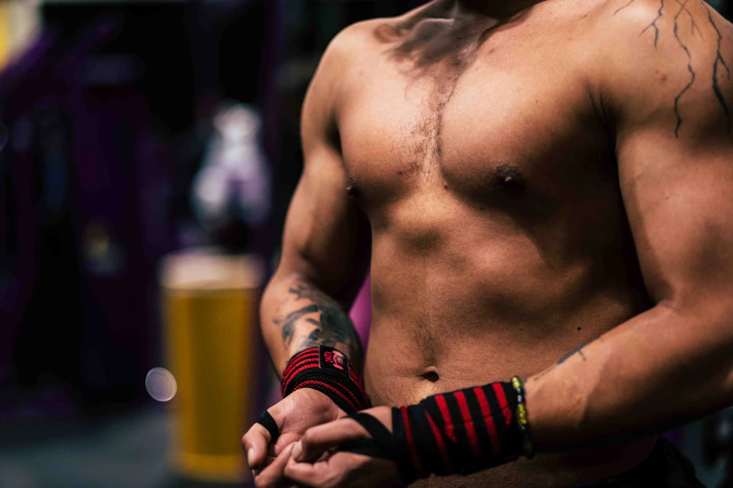 a close up of a shirtless man with tattoos
