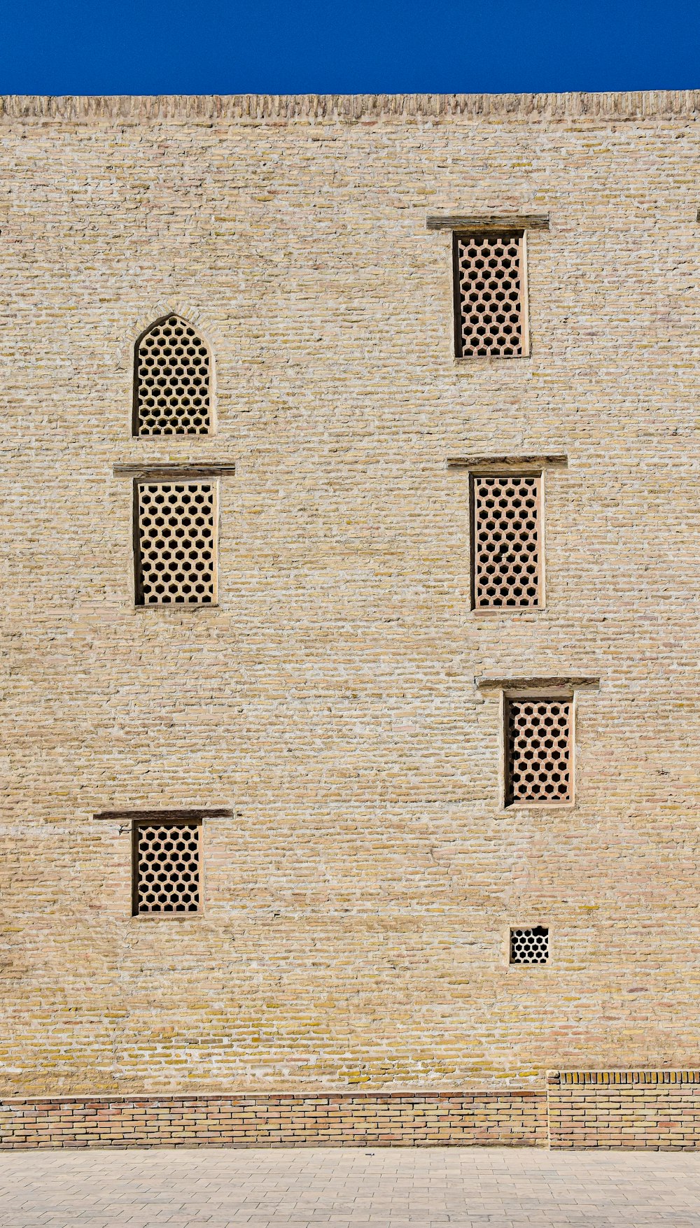 a man riding a skateboard past a tall brick building