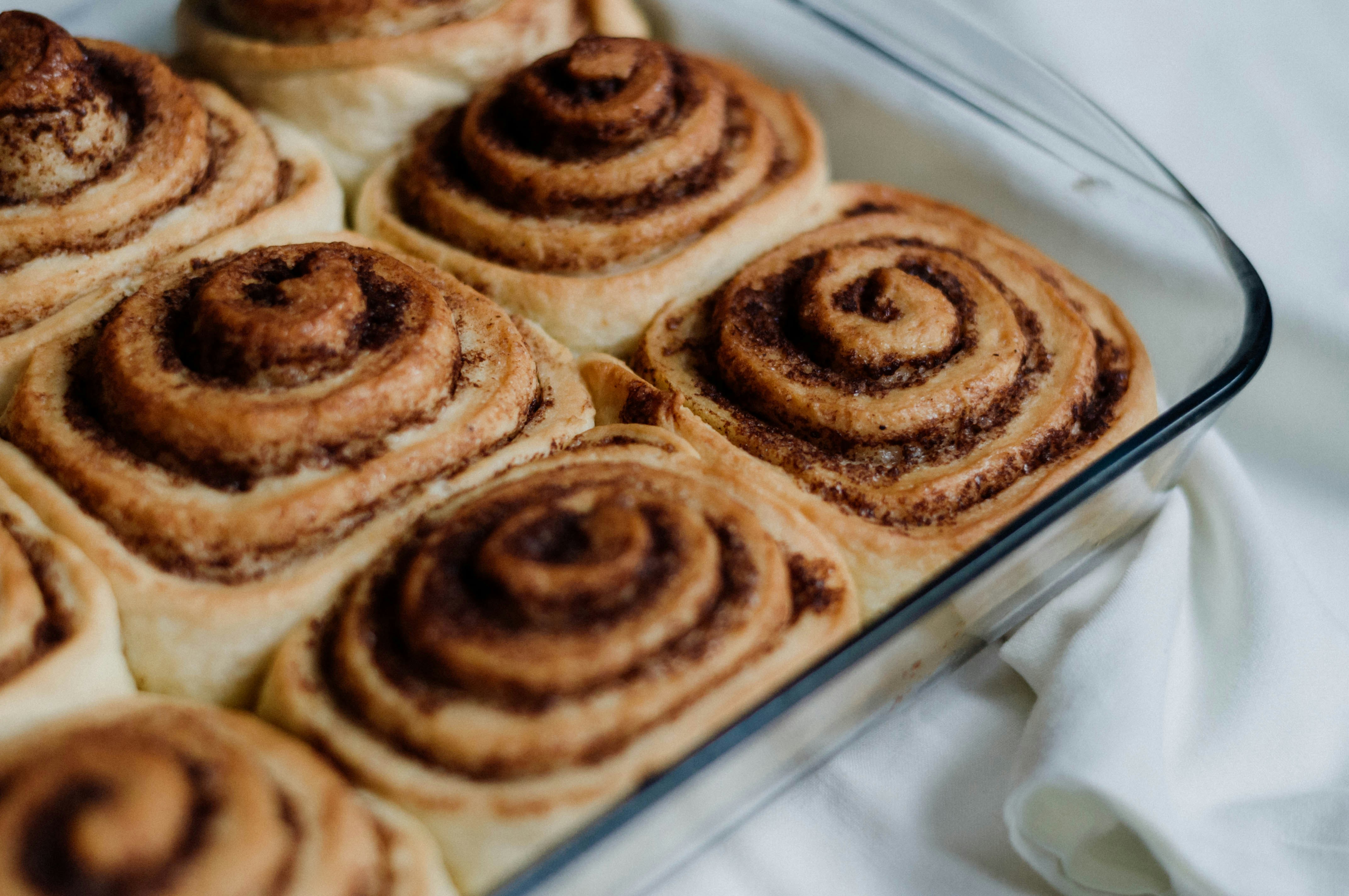 a pan filled with cinnamon rolls on top of a table, 