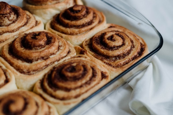 A pan filled with cinnamon rolls on top of a table