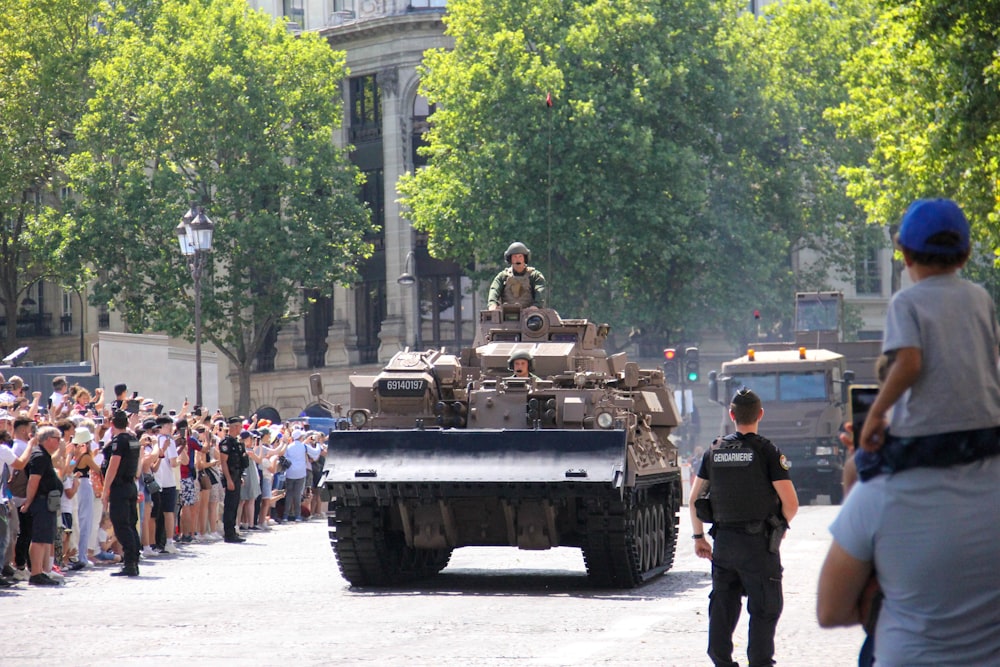 un grand groupe de personnes regardant un véhicule militaire