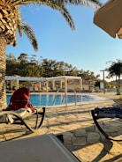 A tranquil luxury pool area with blue tiles and golden accents at dawn.