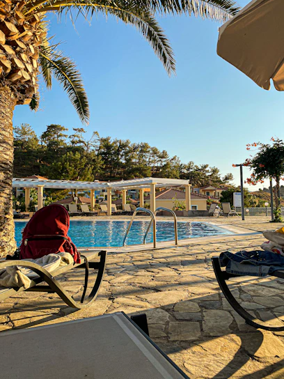 Sunlight gently reflecting off the calm, inviting waters of the central pool framed by natural stone and soft beige loungers.