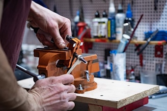 a man is working on a piece of wood