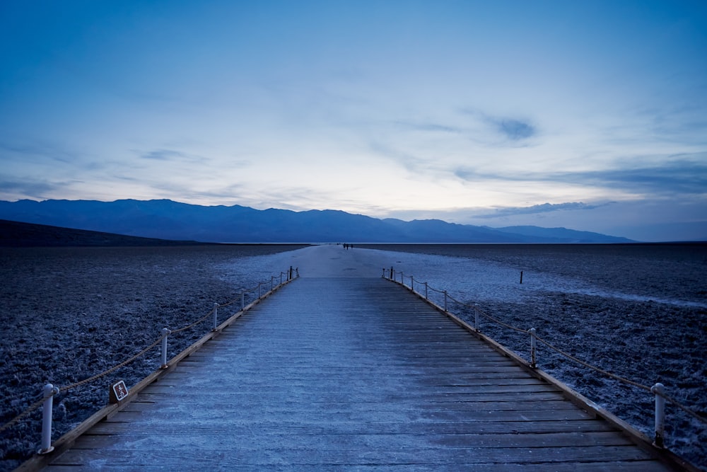 a long wooden walkway in the middle of a desert