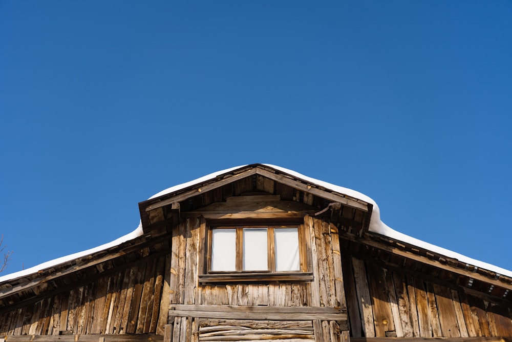 a wooden building with a snow covered roof