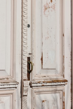 Old wooden door with peeling paint being restored.