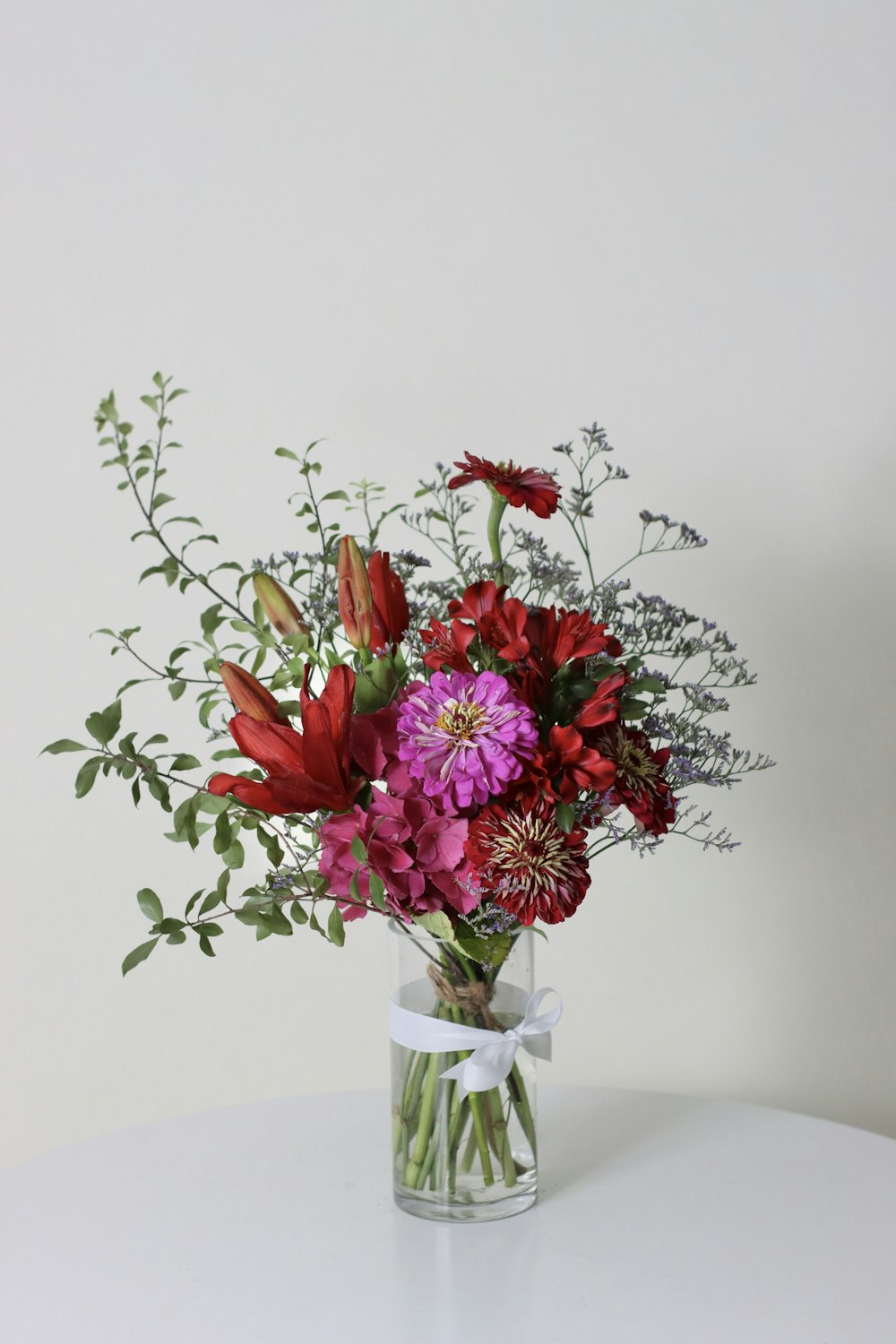 a vase filled with lots of flowers on top of a table