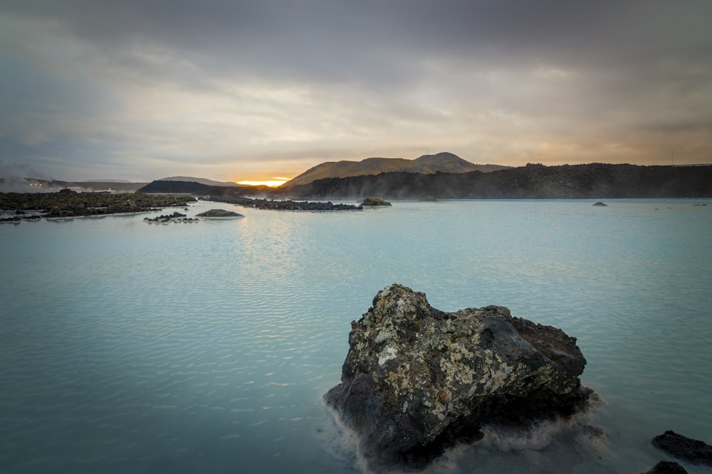 a body of water with a rock in the middle of it