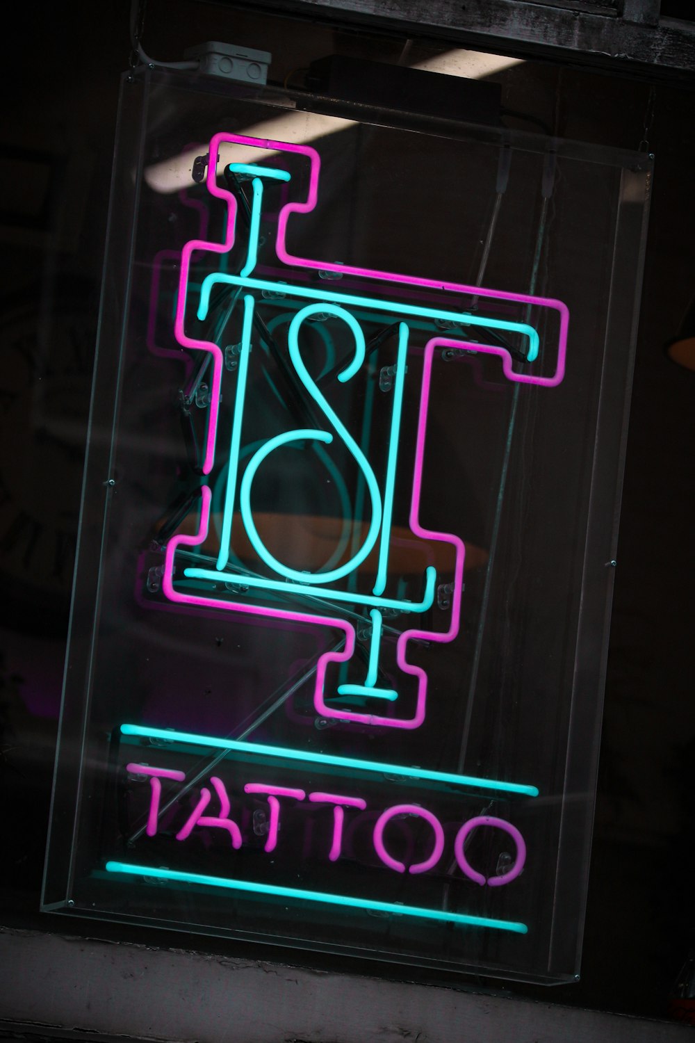 a neon sign that says tattoo on it