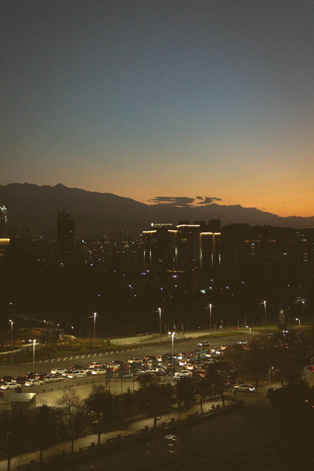 a view of a city at night with mountains in the background