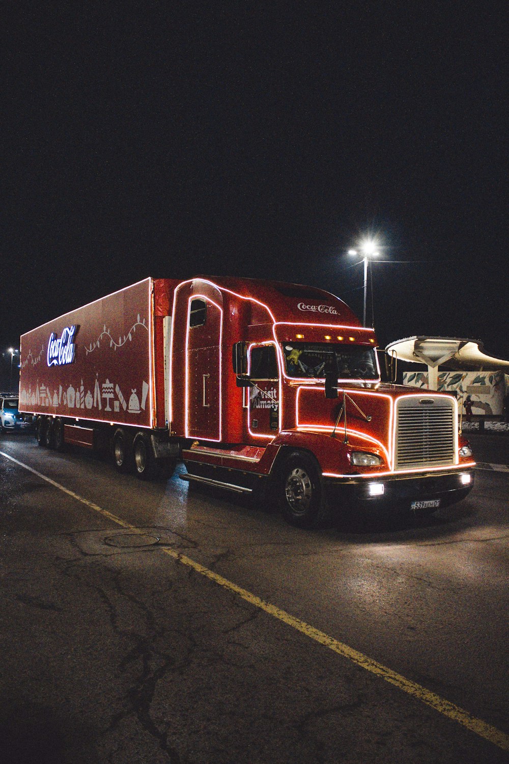 a red semi truck driving down a street at night