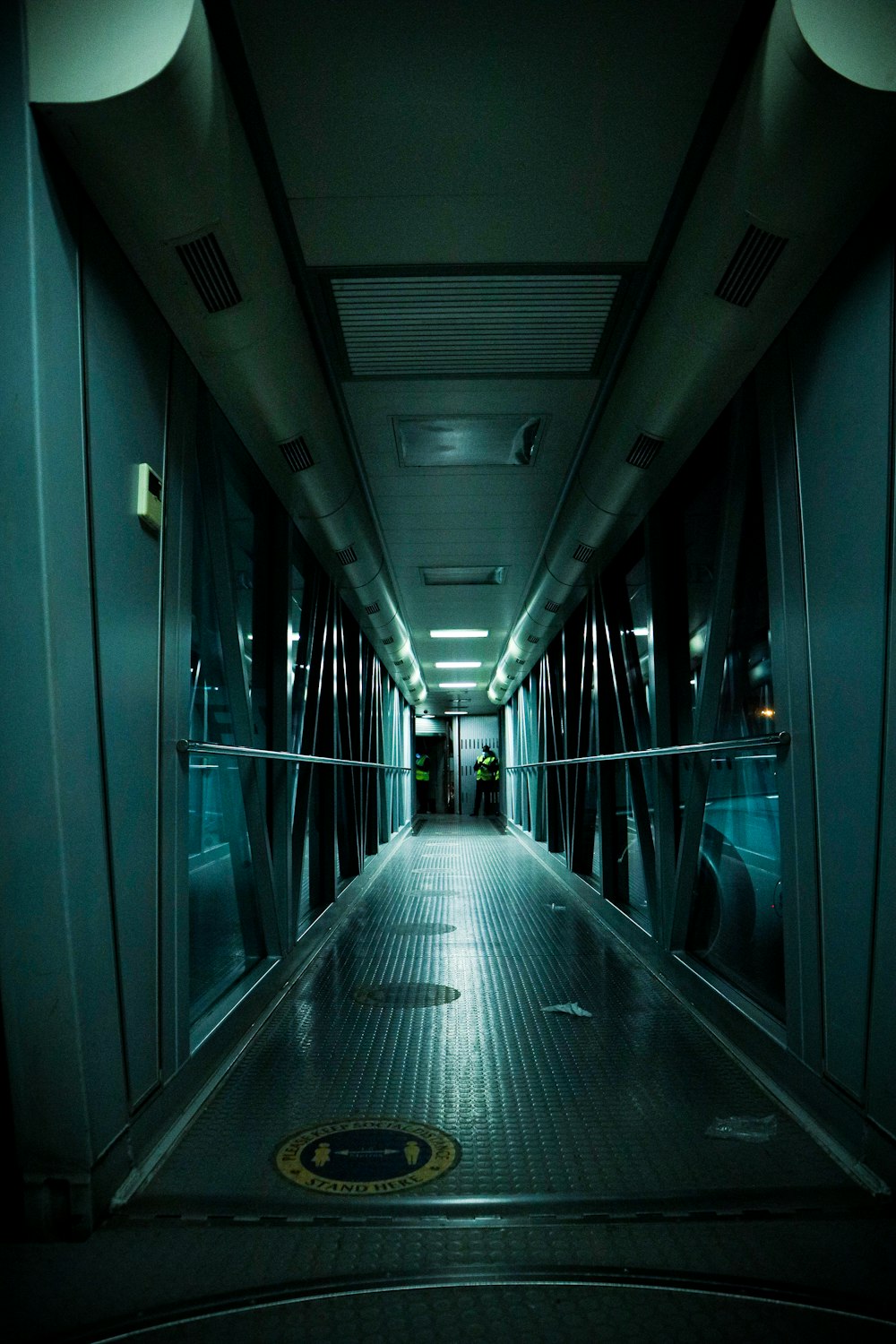 a long hallway with a metal railing leading to another room