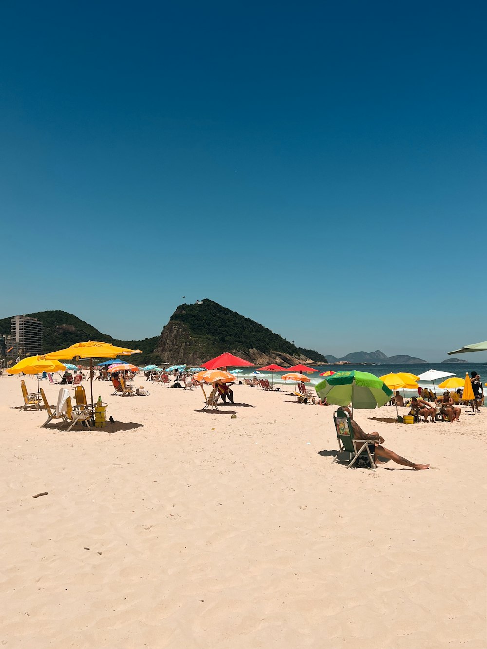 a group of people sitting under umbrellas on a beach