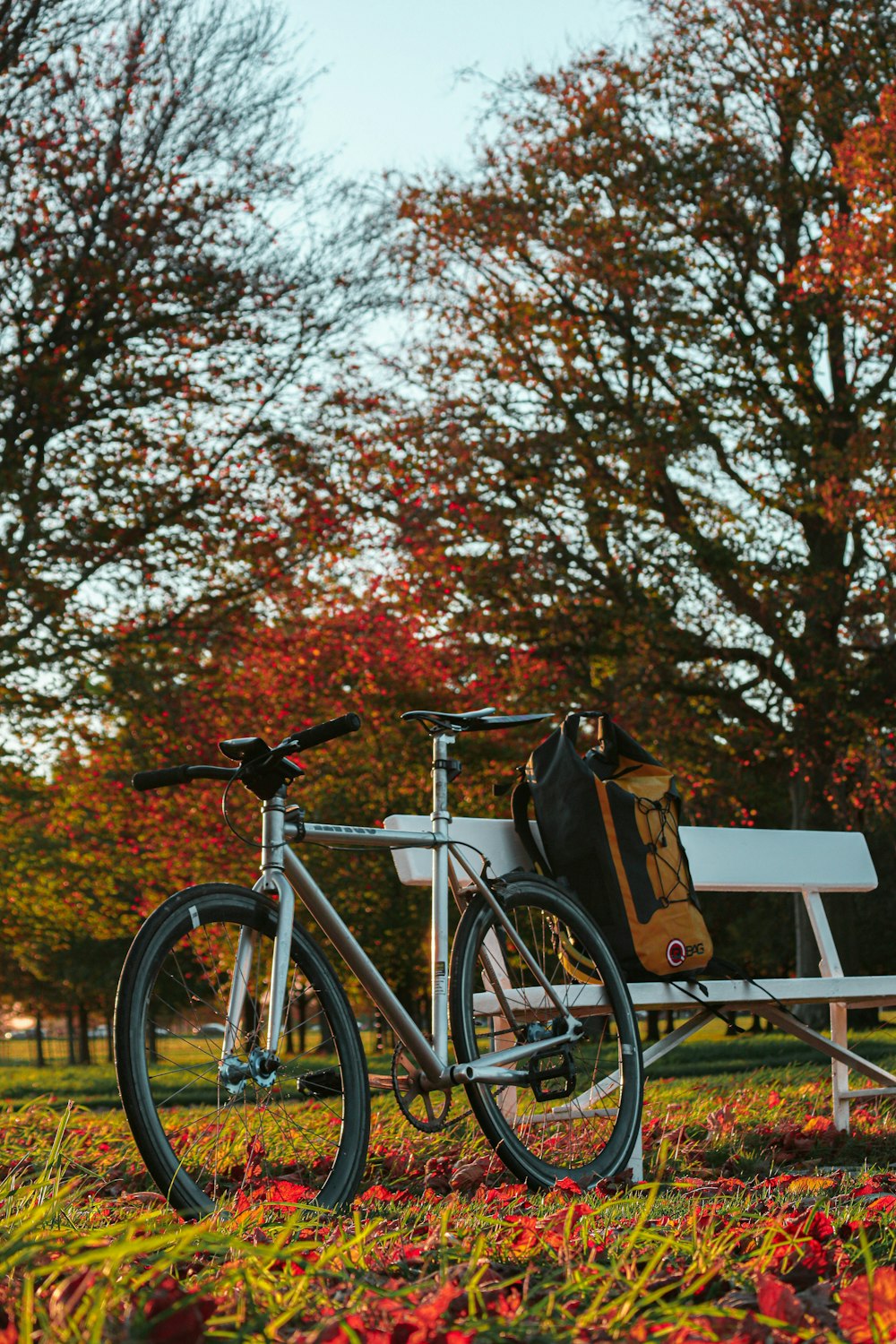a bike parked next to a bench in a park