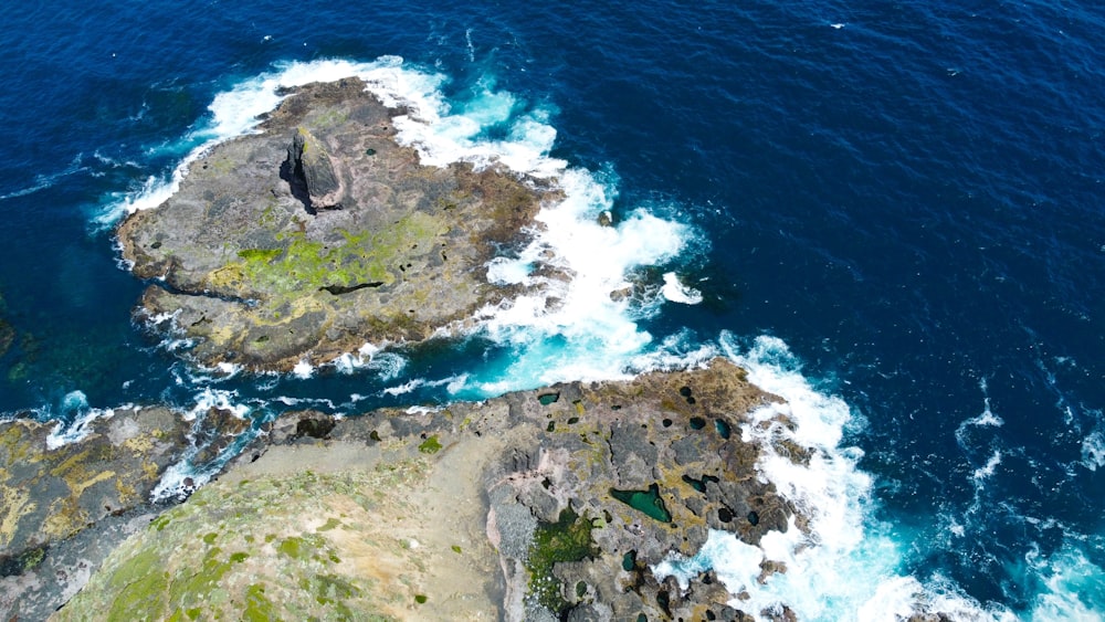 a bird's eye view of the ocean and rocks