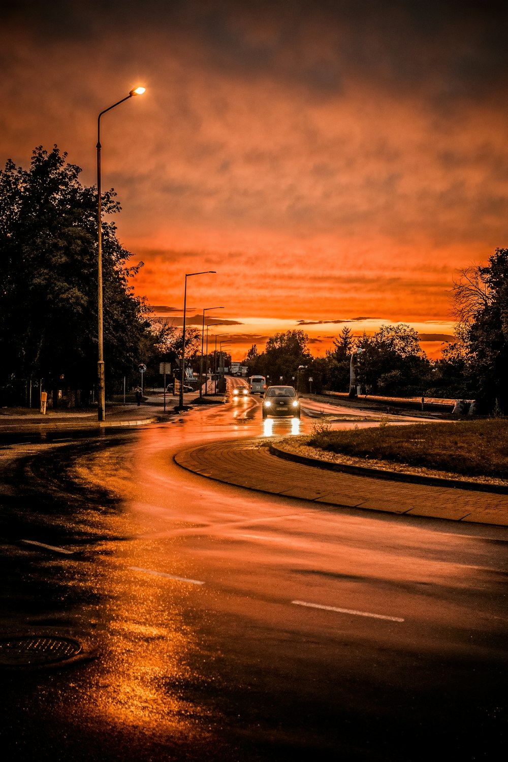 a street at night with cars driving on it