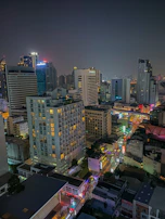 A nighttime cityscape view from a high-rise window, showcasing the vibrant LA nightlife.