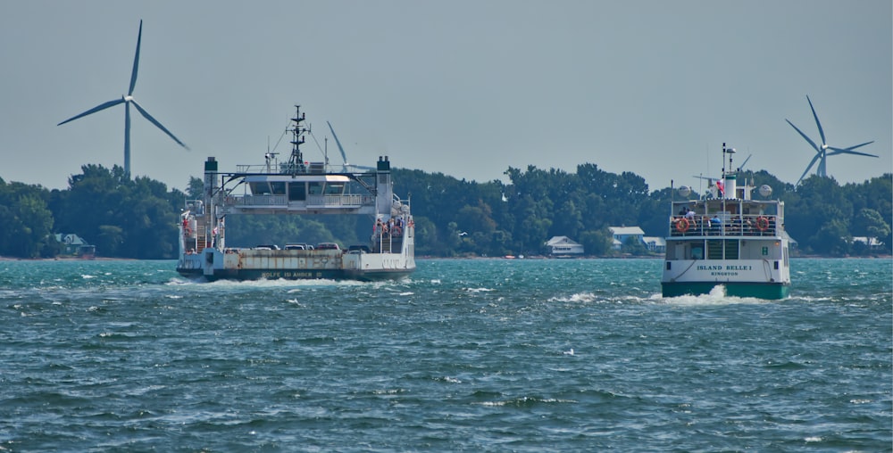 two boats in a body of water with windmills in the background