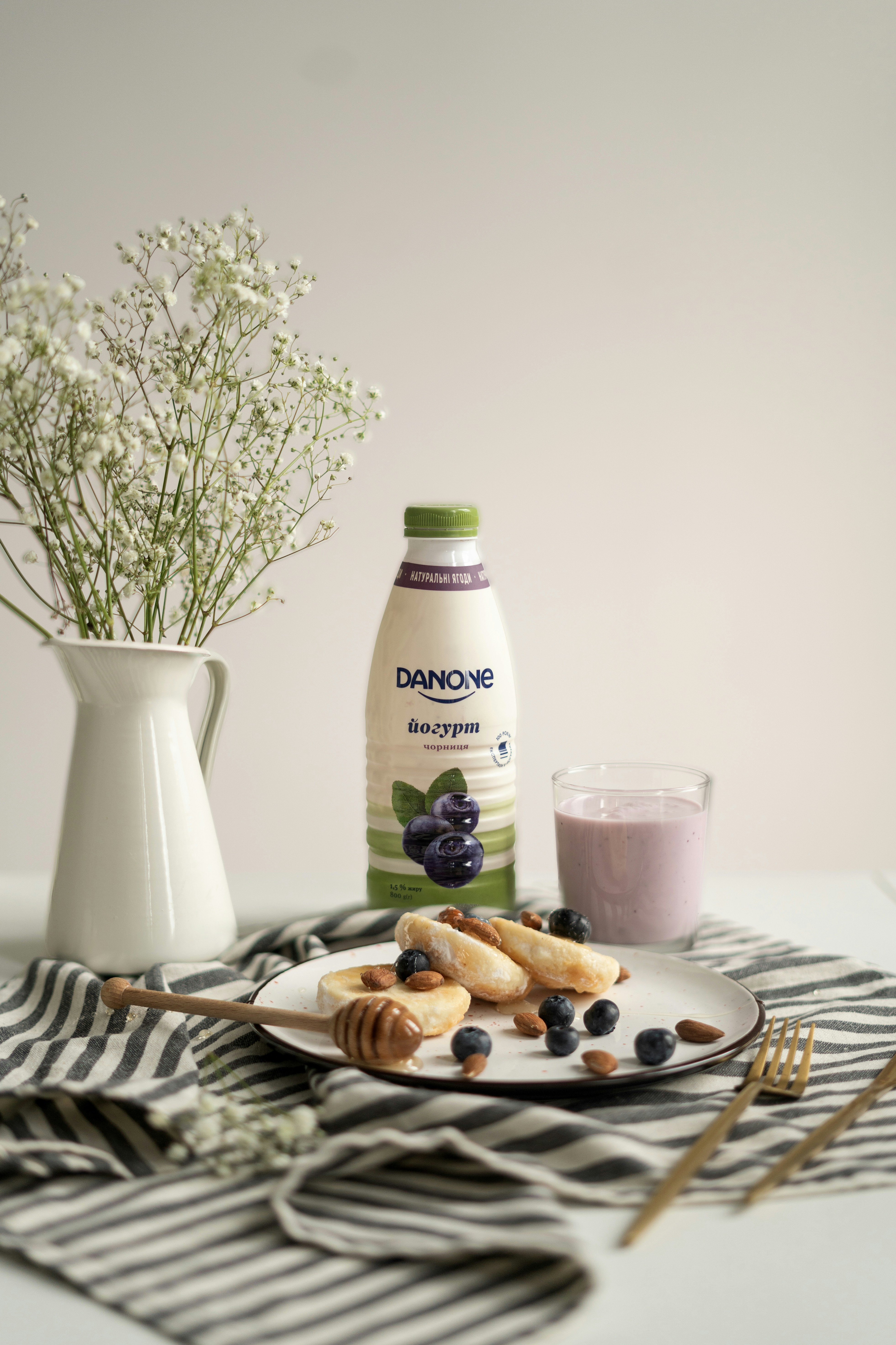 a white plate topped with blueberries next to a bottle of milk