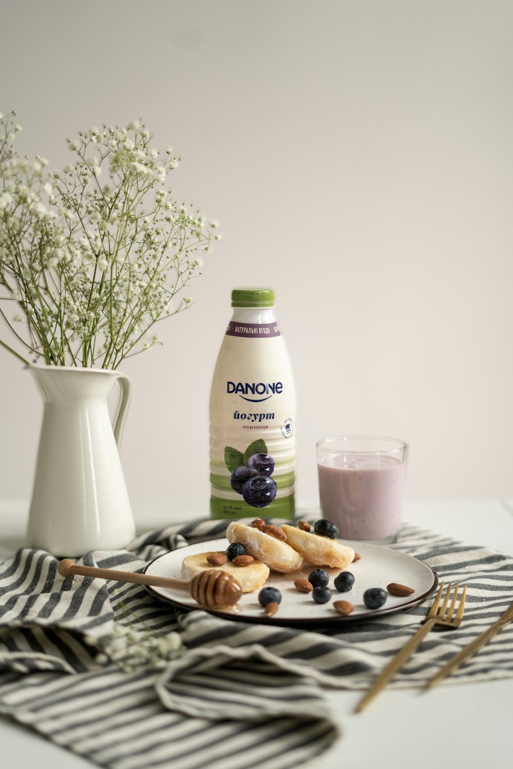 a white plate topped with blueberries next to a bottle of milk